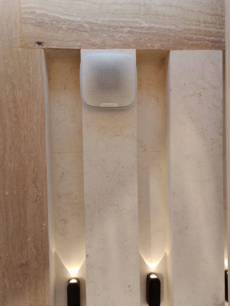 Ajax wireless indoor siren installed in marble feature wall luxury villa Ajman UAE
